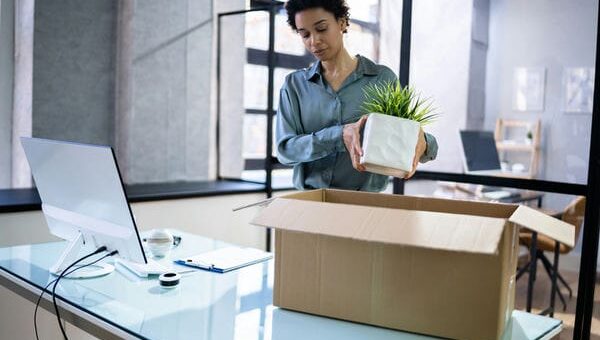 Frau packt Ihre Sachen aus Büroraum