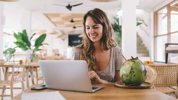 Frau sitzt am Laptop in einem Innenbereich in Thailand