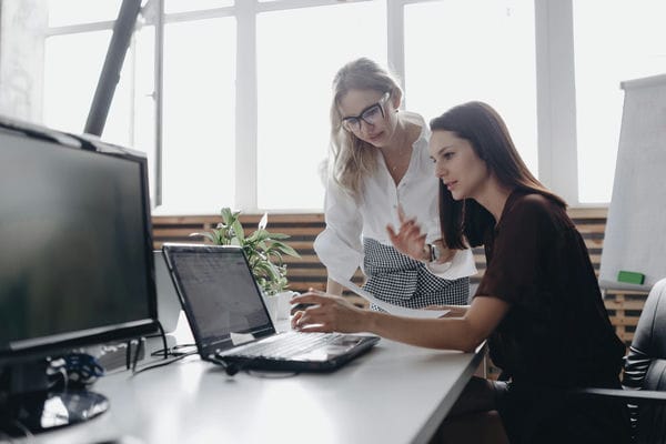 Zwei Kolleginnen besprechen den Dienstplan des kommenden Monat im Büro
